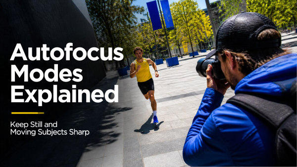Photographer tracking an approaching runner with a mirrorless camera in a sunlit plaza.